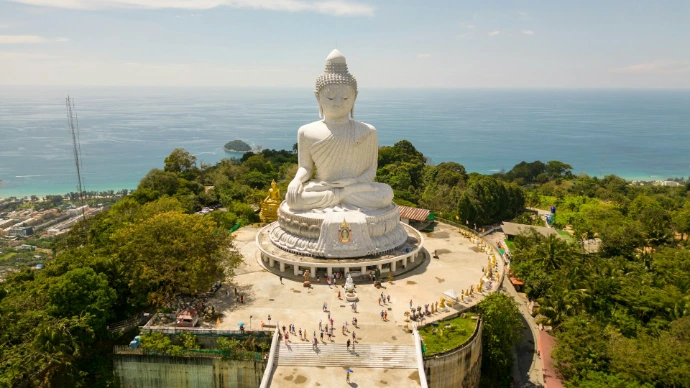 Large white buddha statue overlooking the ocean